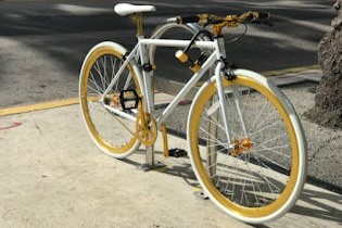 Yellow wheel bicycle locked on stand