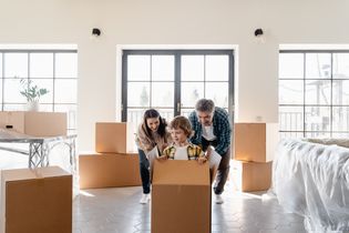 A cheerful family unpacks moving boxes in their new home, creating joyful memories.